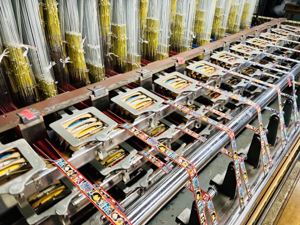 A vibrant variety of colorful ribbons are being produced here.